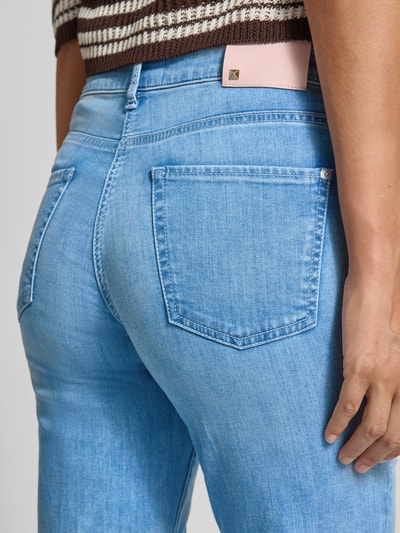 Frauenmodel trägt Flared Fit Jeans aus Baumwoll-Mix Modell 'PARIS' von Cambio, Denim-Optik, Label-Patch, 5-Pocket-Design, Nahaufnahme Rückansicht.