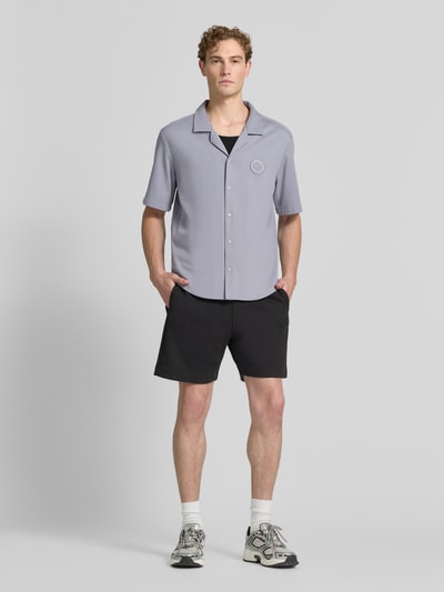 Mężczyzna model nosi koszulę casualową o kroju relaxed fit z mieszanki wiskozy, model 'ST_UNION S' od BOSS Green, jasnoszara, gładka faktura, pełny widok z przodu.