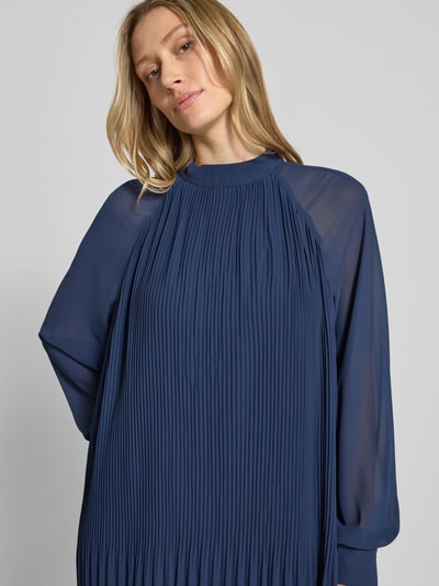 Frauenmodel trägt Minikleid mit Plisseefalten Modell 'Ingrid' von GUIDO MARIA KRETSCHMER WOMAN, fließender Stoff, Stehkragen, Gerader-Schnitt, Nahaufnahme Oberkörper.