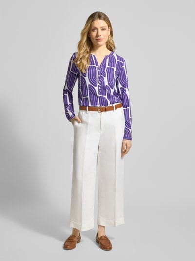 Frauenmodel trägt Wellen-Print Schlupfbluse aus Viskose von Christian Berg Woman in Lila-Weiß, Regular-Fit, V-Ausschnitt, Ganzkörperansicht von vorne.