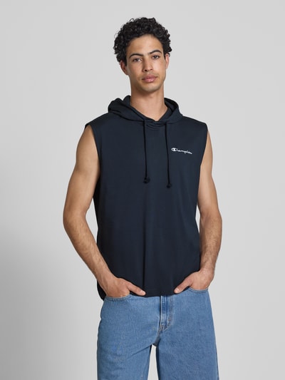 Männermodel trägt Hoodie mit Label-Stitching von CHAMPION in Schwarz aus Reine Baumwolle, Regular-Fit, mit Kapuze und Tunnelzug, Nahaufnahme Oberkörper.