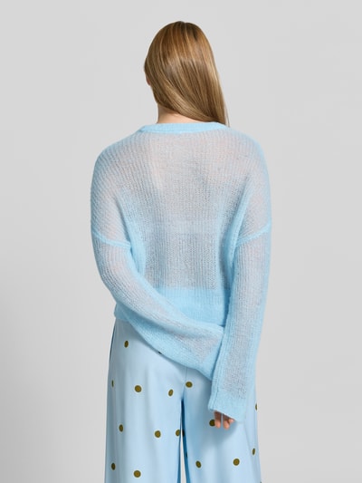 Frauenmodel trägt sommerlichen cropped Strickpullover - curated by Mary Braun von Style Icon Collection in Hellblau, Strick-Optik, Relaxed-Fit, Rundhalsausschnitt, elastische Abschlüsse, Rückenlänge bei Größe S: 53 cm, Ärmellänge bei Größe S: 72 cm, feine transparente Textur, Ganzkörperansicht Rückansicht.