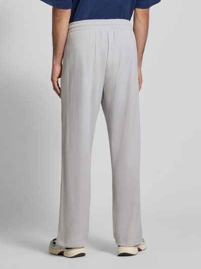 Männermodel trägt Straight fit Sweatpants mit structuurpatroon Model 'Essentials' van adidas Originals, materiaalmix met katoen, elastische band, steekzakken, binnenbeenlengte maat M 77 cm, Ganzkörperansicht Rückansicht.