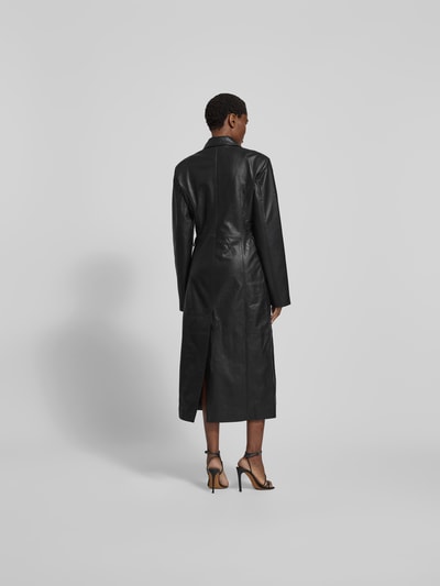 Frauenmodel trägt Mantel aus echtem Lammleder von ROTATE in Schwarz, taillierte Passform, Reverskragen, doppelte Knopfleiste, Überschlag-Taschen, Rückenlänge 128 cm, Brustweite 46 cm, Ärmellänge 68 cm, Ganzkörperansicht Rückansicht.