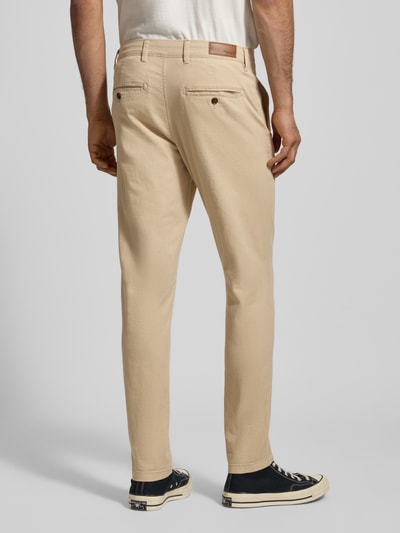 Mannenmodel draagt Slim Fit Hose mit Gesäßtaschen Modell 'MARCO' van Jack & Jones, beige kleur, katoen-elastaan, achterkant volledige lichaamsopname.