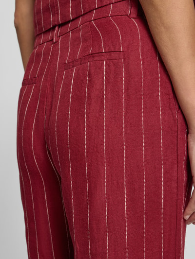 Frauenmodel trägt Wide Fit Leinenhose mit Viskose-Anteil Modell 'Claritte' von MSCH Copenhagen im Leinen-Mix mit feinem Streifenmuster, Eingriff- und Gesäßtaschen, Detailaufnahme Rückansicht.