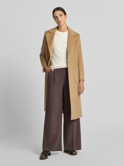 Frauenmodel trägt Wide Fit Hose mit Bundfalten von Rich & Royal in Braun, gerade Form, glatte Textur, Ganzkörperansicht von vorne, Damen Hose, Bundfalten, Gesäßtaschen, Haken- und Reißverschluss, Bundweite 37 cm, Innenbeinlänge 80 cm.