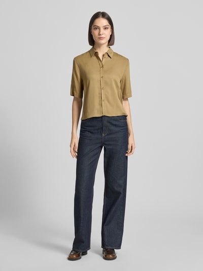 Vrouwenmodel draagt blouse met korte mouwen uit zuiver viscose met 1/2-mouwen van JAKE*S STUDIO WOMAN, slim fit, kentkraag, ruglengte 54 cm bij maat 36, mouwlengte 29 cm bij maat 36, effen khaki, gladde textuur, recht model, voorkant volledig zichtbaar, ganzekörperansicht van voren.