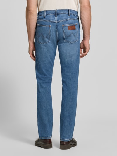 Mężczyzna nosi Regular Taper Jeans aus Baumwoll-Mix Modell 'Redford' od Wrangler, niebieski denim, gładka tekstura, Ganzkörperansicht Rückansicht.