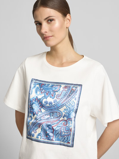 Kobiece modelka nosi damski t-shirt z motywem, pudełkowy krój, bawełna, okrągły dekolt, długość tyłu 55 cm w rozmiarze 36, Oui, zbliżenie na górną część ciała.