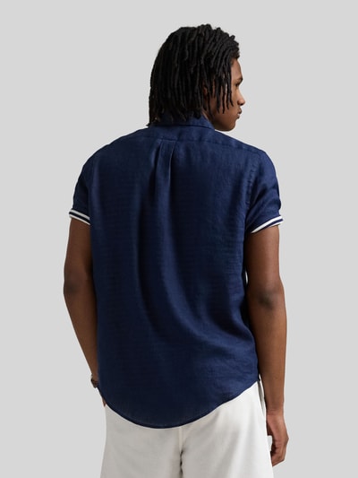 Mannermodel draagt Regular Fit Leinenhemd mit Button-Down-Kragen van Polo Ralph Lauren, look: effen kleuren, pasvorm: regular fit, button-downkraag, korte mouw, rompzoom licht afgerond, materiaal: puur linnen, met gestikt logo, doorlopende knoopsluiting, kleur donkerblauw, hele rugaanzicht