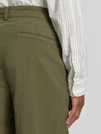Männermodel trägt Straight Fit Chino aus Baumwoll-Mix von BOSS Orange in Olivgrün, strukturierte Textur, Nahaufnahme Rückansicht.