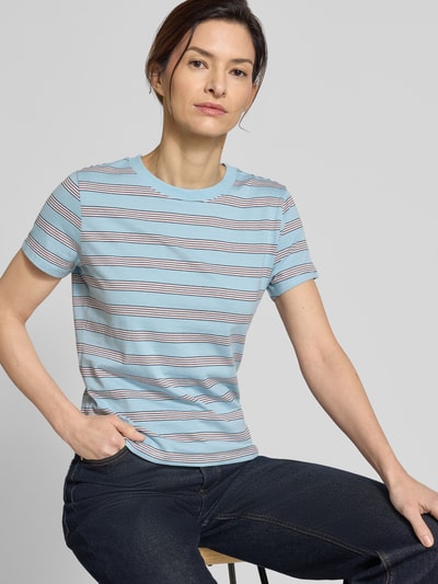 Modelka kobieca nosi Regular Fit T-Shirt aus reiner Baumwolle von Tom Tailor Denim, wielokolorowe paski, okrągły dekolt, krótki rękaw, jersey, detal z logo, widok na górną część ciała z przodu.