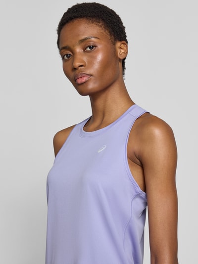 Kobiece modelka nosi top z okrągłym dekoltem Model 'CORE' od ASICS TIGER, krój regular fit, nadruk z logo, długość tyłu 62 cm, zbliżenie na górną część ciała.