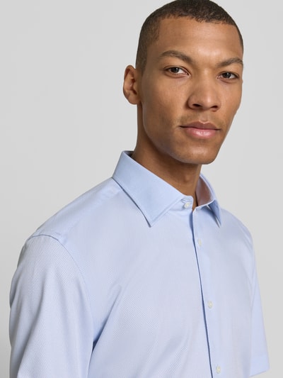 Männermodel trägt Regular Fit Businesshemd aus Baumwoll-Mix Modell 'H-JOE-K-SH-C1-262' von BOSS, Allover-Muster, Nahaufnahme Oberkörper.