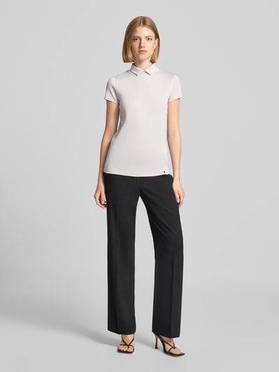 Frauenmodel trägt Slim Fit T-Shirt mit hochschließendem Polokragen von Marc Cain, Baumwoll-Elasthan-Mix, 1/2-Arm, weiß, Ganzkörperansicht von vorne.