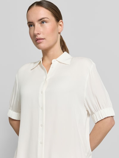 Frauenmodel trägt Regular Fit Bluse aus Viskose mit 1/2-Arm von Emily Van den Bergh in Creme mit Hemdblusenkragen, Knopfleiste, Nahaufnahme Oberkörper. Rückenlänge in Größe 36: 54 cm, Ärmellänge: 26 cm, glatte Textur.
