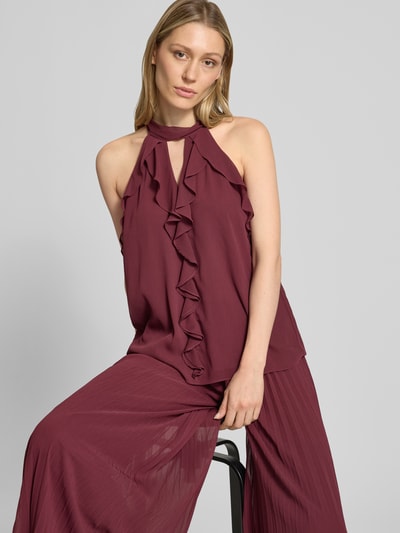 Frauenmodel trägt Top mit Volants und Neckholder von V by Vera Mont aus bordeauxfarbenem Chiffon mit Cut Outs, Nahaufnahme Oberkörper.