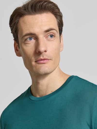 Mannenmodel draagt T-Shirt met Rundhalsausschnitt van Christian Berg Men, reine katoen, regular fit, smaragdgroen, close-up bovenlichaam.