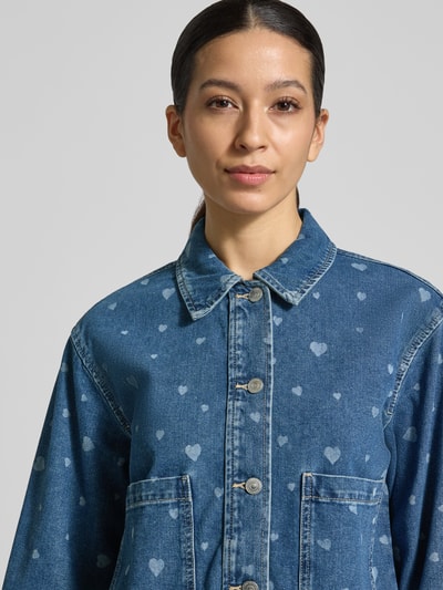 Frauenmodel trägt Oversized Jeansjacke aus reiner Baumwolle von Tom Tailor Denim in Denim-Optik mit Allover-Muster, Nahaufnahme Oberkörper.