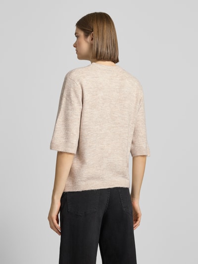 Frauenmodel trägt Regular Fit Cardigan mit Schnürungen Modell 'SIMONI' von Only in unifarbener Strickoptik, Ganzkörperansicht Rückansicht.