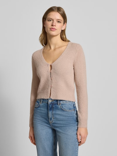 Frauenmodel trägt Slim Fit Strickjacke mit einreihiger Knopfleiste Modell 'KERRY' von Only, Optik: Unifarben, V-Ausschnitt, gerippte Abschlüsse, Materialverarbeitung: Strick, Ganzkörperansicht von vorne.