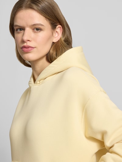 Vrouwenmodel draagt Regular Fit Hoodie met kangoeroezak model 'Iconic' van Gina Tricot, katoenmix, dames, detailopname bovenlichaam.