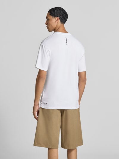 Mannenmodel draagt T-shirt met ronde hals en logo van Quiksilver, materiaalmix met stretch, regular fit, ruglengte maat M 75 cm, geheel van achteren te zien.