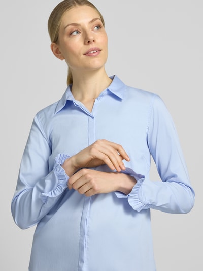 Kobiece modelka nosi bluzkę koszulową z mieszanki bawełny Model 'Mattie' od MOS MOSH, krój slim fit, jasnoniebieska, kołnierzyk koszulowy, długie rękawy z falbanami, zaokrąglony dół, długość tyłu 70 cm, długość rękawów 62 cm, ujęcie z przodu, zbliżenie górnej części ciała.
