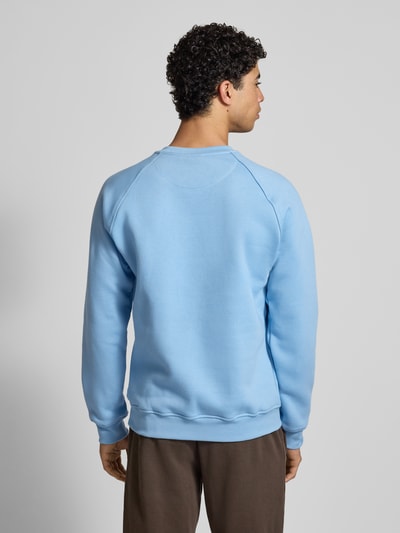 Männermodel trägt Sweatshirt mit Label-Stitching von adidas Originals in Hellblau, Baumwoll-Mix, lockerer Schnitt, gerippte Abschlüsse, Rundhalsausschnitt, Rückenlänge 70 cm, Ärmellänge 82 cm, Ganzkörperansicht Rückansicht.