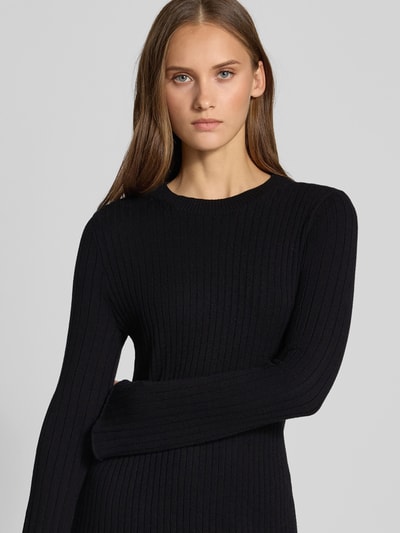 Frauenmodel trägt eng anliegendes Freizeitkleid aus Viskose-Mix Modell 'MICHELLA' von ONLY, schwarz gerippt, Nahaufnahme Oberkörper, Damen Strickkleid von ONLY