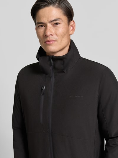 Męski model prezentuje Regular Fit Parka mit Logo-Print von Lindbergh, elastyczna mieszanka materiałów, czarny, zamek błyskawiczny, nadruk z logo, kaptur z tunelem, napoleońska kieszeń, Szerokość w rozmiarze M: 50 cm, Szerokość klatki piersiowej w rozmiarze M: 58 cm, Długość rękawów: 65 cm, Długość tyłu: 90 cm, ujęcie: zbliżenie górnej części ciała od przodu
