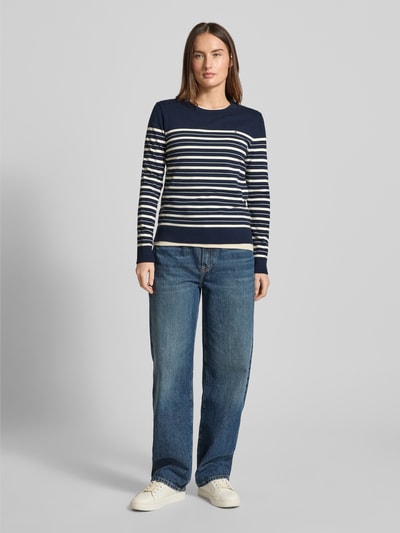 Vrouwenmodel draagt Regular Fit Strickpullover aus Baumwoll-Mix van Tommy Hilfiger, blauw-wit gestreept, ribstructuur, voorkant, full body.