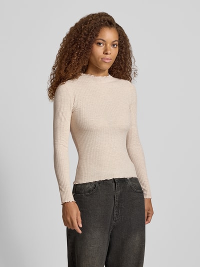 Kobiece model prezentuje bluzkę z długim rękawem w kolorze beżowym, model 'EMMA' z dodatkiem wiskozy od ONLY, krój slim fit, całkowity widok z przodu.