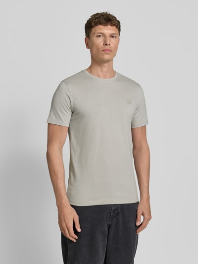 Männermodel trägt Regular Fit T-Shirt aus reiner Baumwolle Modell 'TALES' von BOSS Orange, Optik: Unifarben, Label-Patch, Rundhals, Kurzarm, Jersey, Ganzkörperansicht von vorne.