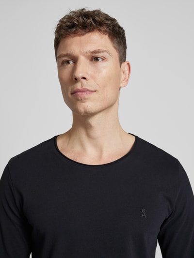 Männermodel trägt Regular Fit Langarmshirt aus reiner Baumwolle Modell 'JAAMES' von Armedangels, unifarbenes Jersey, Nahaufnahme Oberkörper.