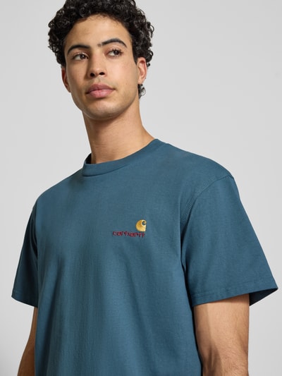 Männermodel trägt T-Shirt mit Label-Stitching von Carhartt Work In Progress in Blau, Reine Baumwolle, Regular-Fit, Nahaufnahme Oberkörper.