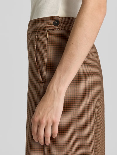 Frauenmodel trägt Relaxed Fit Stoffhose mit Schurwoll-Anteil Modell 'GHINEA' von Marella, kleinkariertes Muster in Braun und Beige, elastischer Material-Mix mit Bundfalten und Eingriffstasche, Nahaufnahme Oberkörper, Kontext: Damen Stoffhose von Marella, Bundweite 40 cm, Innenbeinlänge 93 cm.