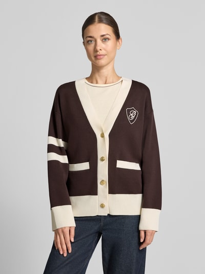 Modelka kobieca nosi 'Relaxed Fit Strickjacke aus reiner Baumwolle' od GANT, kardigan rozpinany w brązowo-kremowych kolorach, faktura gładka, widok całej sylwetki z przodu, kontekst: damski kardigan rozpinany od GANT.
