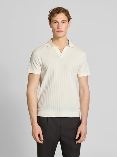 Männermodel trägt Regular Fit Poloshirt mit V-Ausschnitt Modell 'Baronito' von JOOP! Collection in Beige, strukturierte Baumwolle, Ganzkörperansicht von vorne.