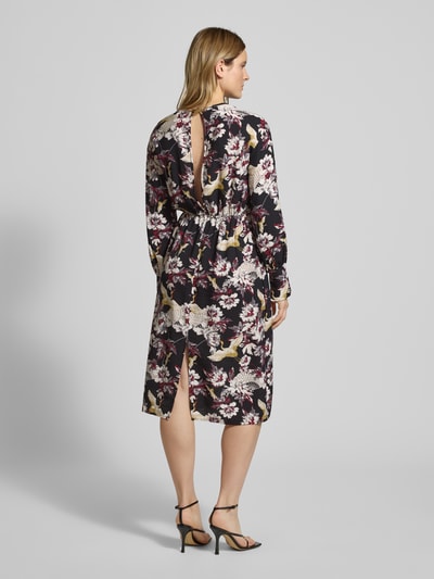 Frauenmodel trägt Midikleid mit Rundhalsausschnitt Modell 'Orelia' von GUIDO MARIA KRETSCHMER WOMAN, schwarzer Viskose-Mix mit floralem Muster, lockerer Schnitt, Raffungen, Rückansicht Ganzkörperansicht.