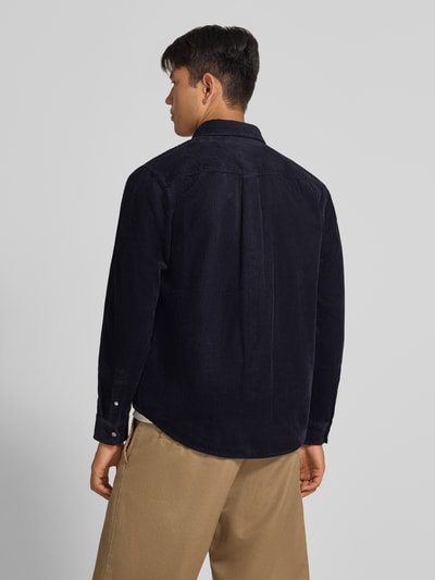 Männermodel trägt Regular Fit Freizeithemd mit Logo-Stitching Modell 'MADISON' von Carhartt Work In Progress aus reiner Baumwolle, dunkelblau mit Knopfleiste und Sportmanschetten, Rückansicht Ganzkörperansicht.