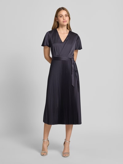 Frauenmodel trägt Midikleid aus Satin mit V-Ausschnitt von Comma, dunkel, taillierte Passform, Plissee-Optik, Kurzärmelig, Stoffband, Ganzkörperansicht von vorne. Rückenlänge 102 cm, Brustweite 34 cm, Ärmellänge 20 cm.
