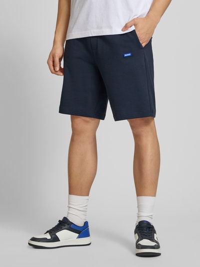 Männermodel trägt Regular Fit Sweatshorts aus reiner Baumwolle Modell 'NASENSIO' von Hugo Blue, Optik: Unifarben, Ganzkörperansicht von vorne