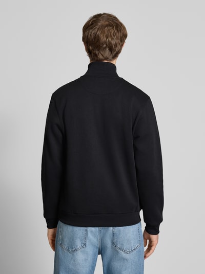Männermodel trägt Regular Fit Sweatshirt mit Troyer-Kragen Modell 'Bradley' von Jack & Jones, schwarze Farbe, Rückansicht, Material-Mix mit Baumwoll-Anteil, elastische Abschlüsse, Rückenlänge 68 cm, Ärmellänge 68 cm. Ganzkörperansicht Rückansicht.