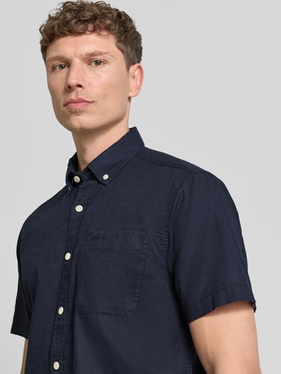 Männermodel trägt Regular Fit vrijetijdsoverhemd met button-downkraag van camel active, mix van katoen en linnen, borstzak, labelstitching. Nahaufnahme Oberkörper.