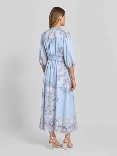 Frauenmodel trägt Maxikleid mit V-Ausschnitt und 3/4-Arm Modell 'Stellar Artist' von Neo Noir im Allover-Look, A-Linie, Rückenansicht. Rückenlänge bei Größe 36: 131 cm, Brustweite 41 cm, Ärmellänge 49 cm.