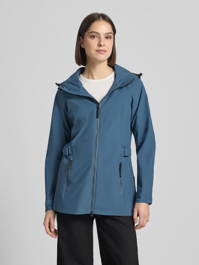 Frauenmodel trägt Regular Fit Regenmantel mit Logo-Detail von G.I.G.A. DX in Blau mit Kapuze, Zweiwege-Reißverschluss, Eingrifftaschen, Ganzkörperansicht von vorne, Rückenlänge 76 cm, Schulterbreite 40 cm, Brustweite 50 cm, Ärmellänge 66 cm bei Größe 36.