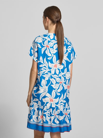 Frauenmodel trägt Knielanges Kleid aus Viskose mit Knopfleiste Modell 'Rylie' von GUIDO MARIA KRETSCHMER WOMAN, blau-weißes Blumenmuster, Gerader-Schnitt, fixierter Aufschlag am Ärmel, Serafino-Kragen, Ganzkörperansicht Rückansicht.