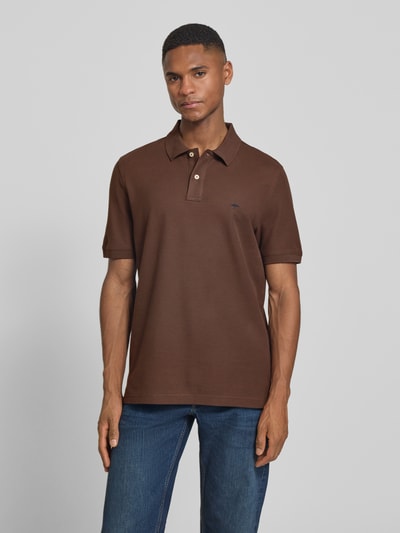 Männermodel trägt Regular Fit Poloshirt mit Logo-Stitching von Fynch-Hatton in Braun, kurze Ärmel, Polokragen, reine Baumwolle, Ganzkörperansicht von vorne.